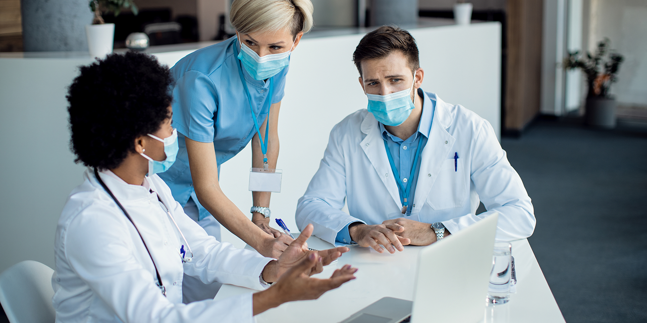 Clinicians reviewing a laptop in a hospital ward